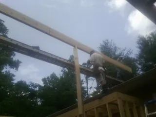Carpenter setting a ridge beam over a new addition frame — Ice Dam Removal by Roofing Brothers in Bulverde