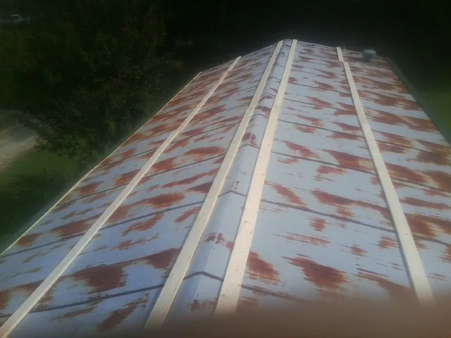 Rusted metal roof panels with new wood purlins before replacement — Storm Damage Roof Repair in Bulverde by Roofing Brothers