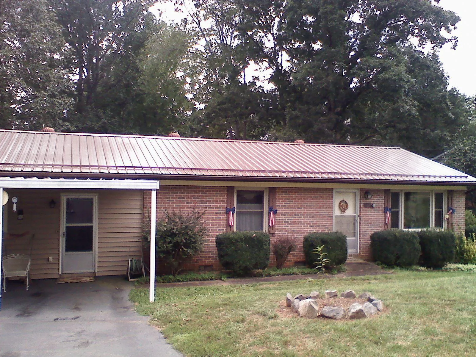 Bronze metal roof and carport on a brick ranch home — Roof Repair work by our crew in Bulverde